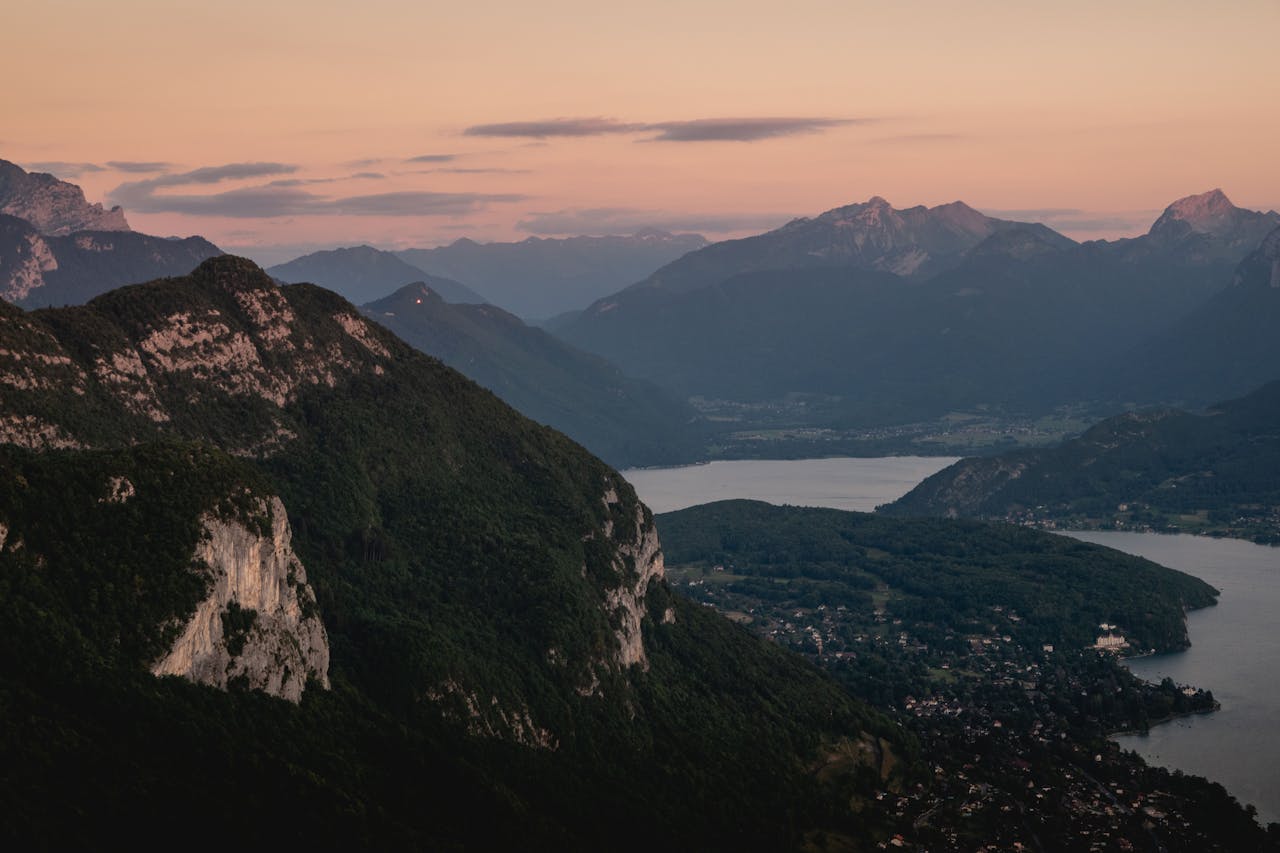 who-we-are A breathtaking aerial view of Annecy mountains and lake at sunset, showcasing natural beauty.